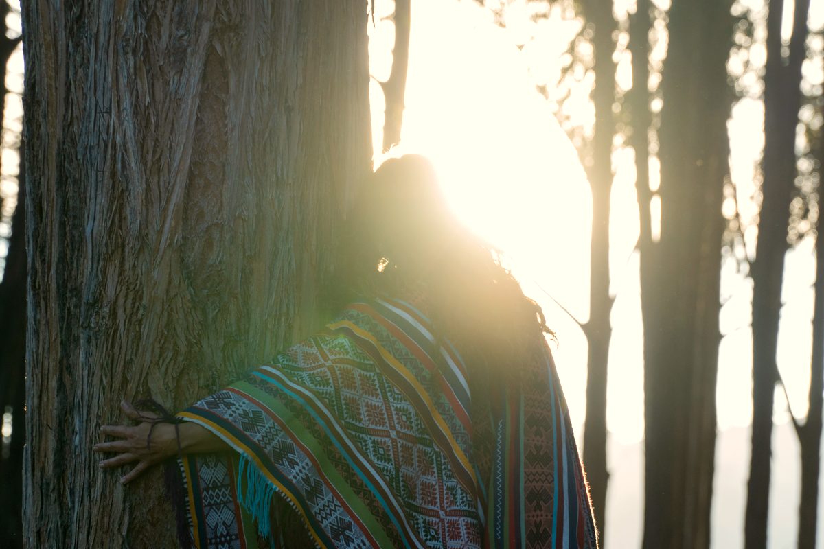 Ritual purificação - mulher sorrindo segurando criança em envoltório tradicional